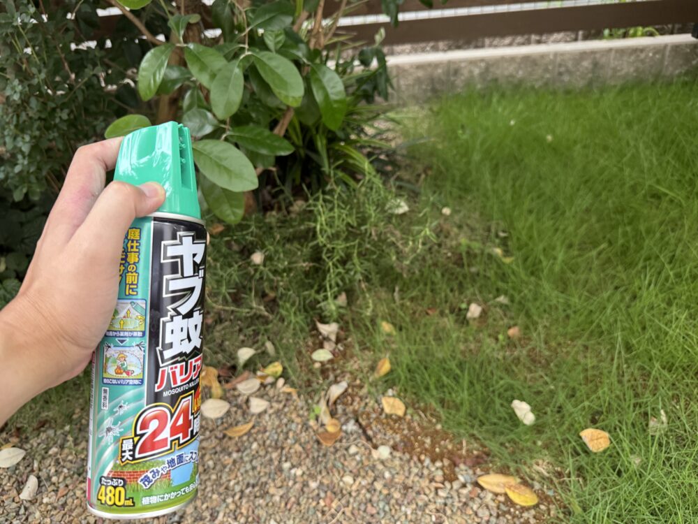 庭の芝生を背景に手に持ったフマキラーのヤブ蚊バリア