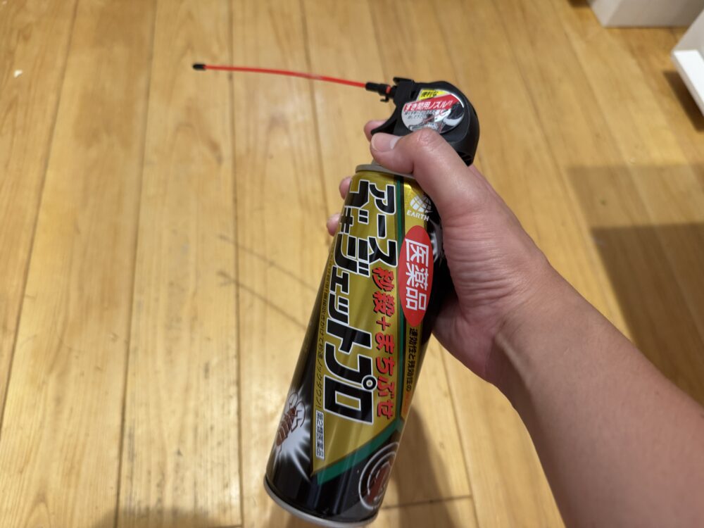 ヒノキの無垢床の上で手に持ったゴキジェットプロ